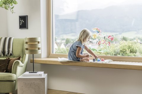Mädchen beim Fenster Mädchen spielt beim Fenster